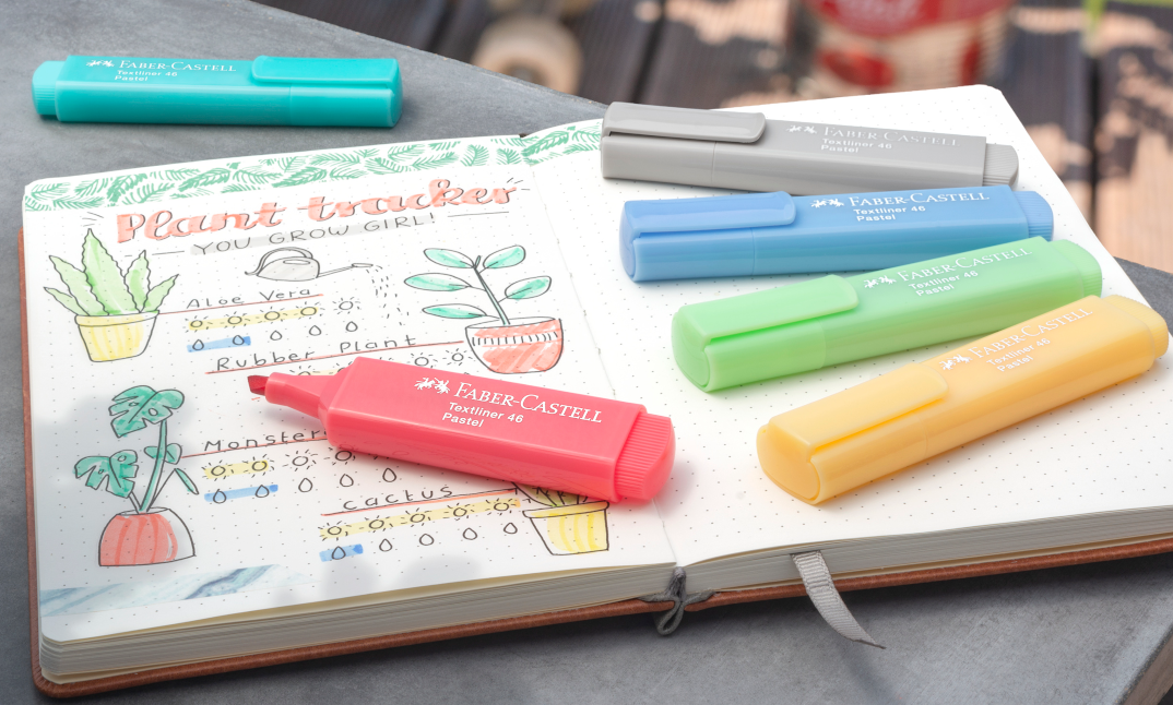 colourful highlighters on a note book with a drawn plant tracker on it 