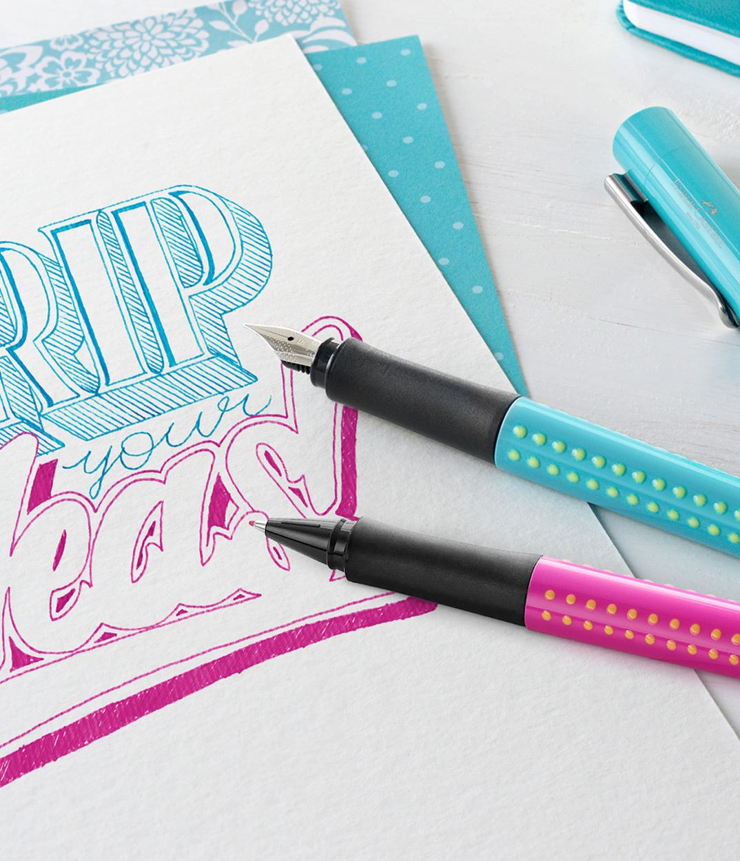 Turquoise grip fountain pen and pink finewriter.